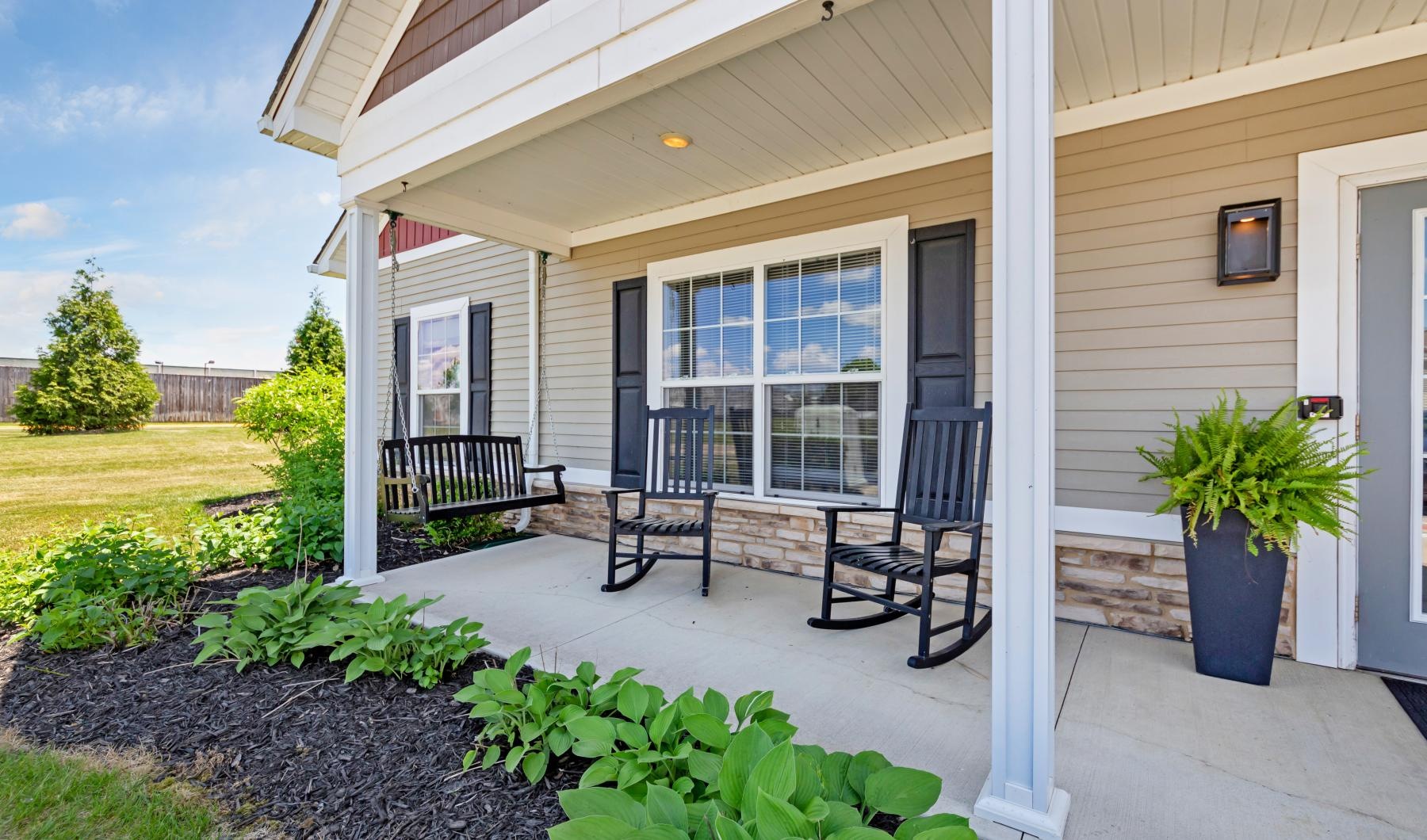 a house with a patio and a chair and a table and plants